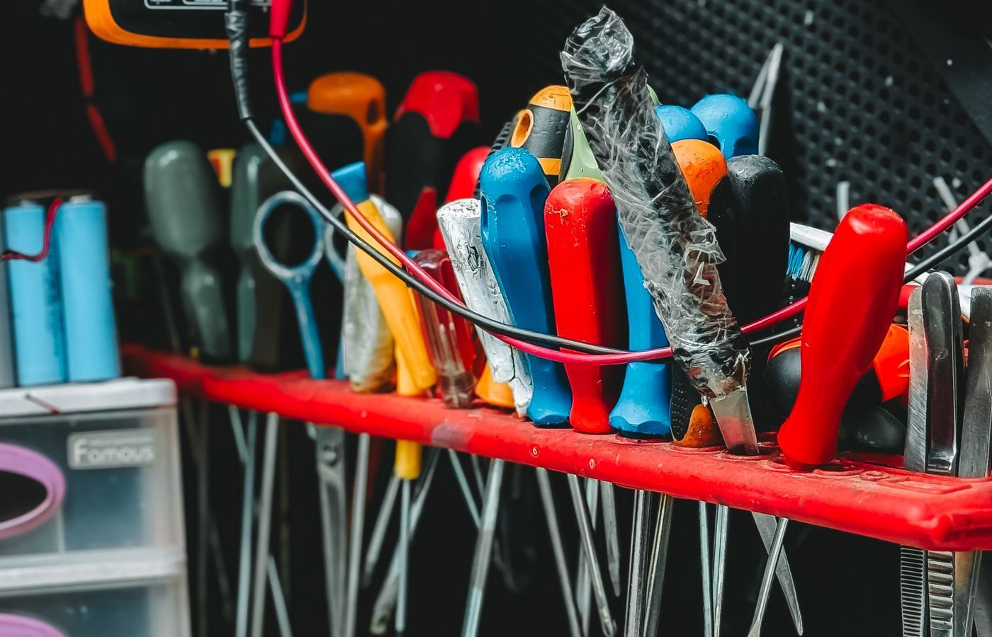 Organised workbench with pliers, screwdrivers and a digital multimeter.