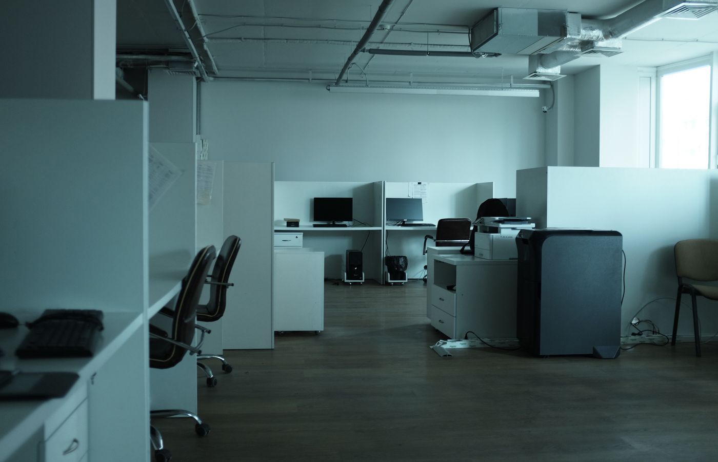 Empty modern office with workstations and contemporary lighting.