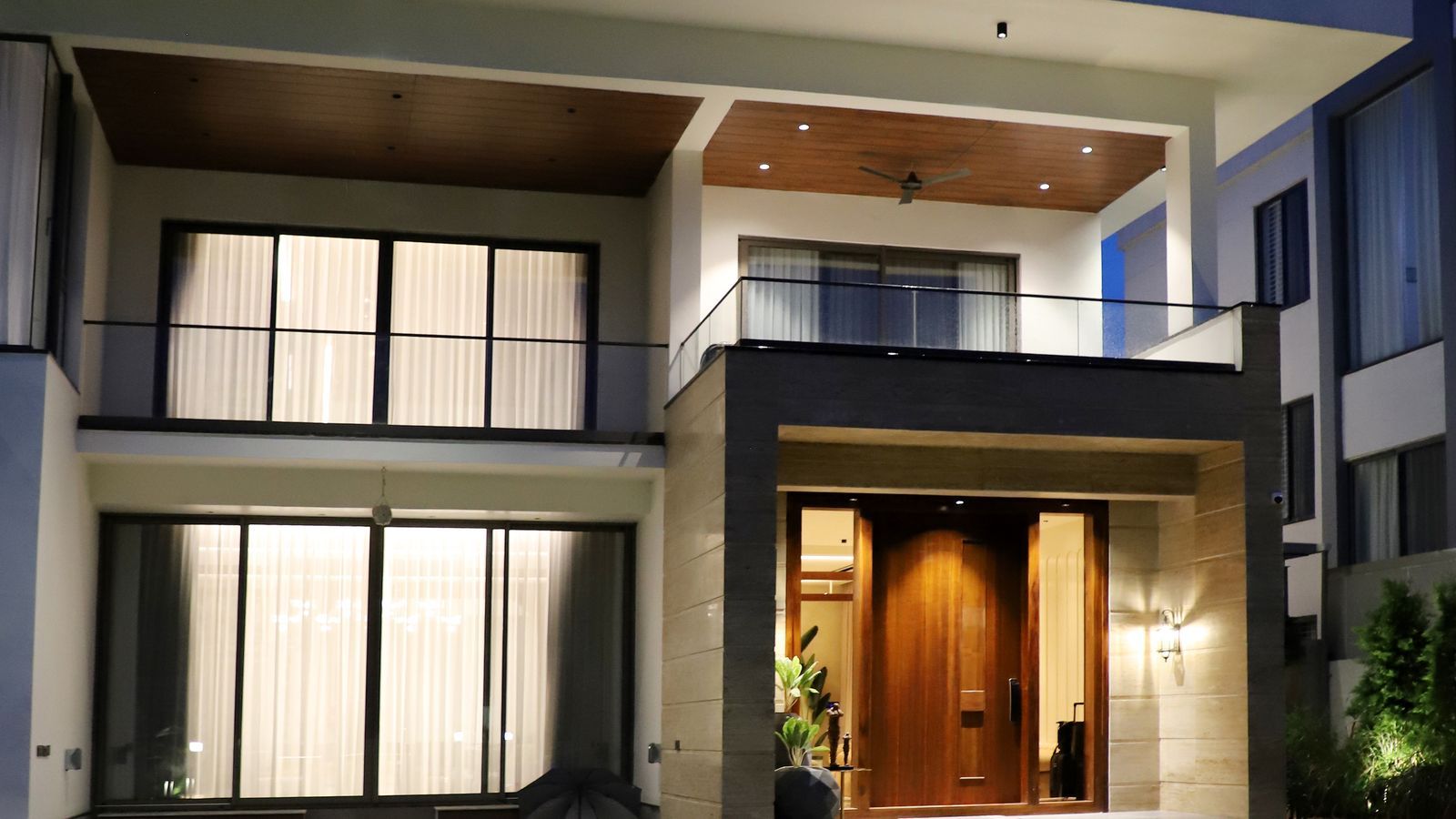 Illuminated modern home exterior at night with clean architectural lines.